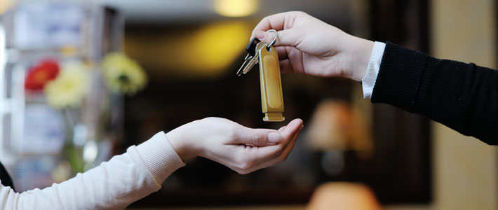 Close Up of Hnads Exchanging Keys in Hotel Lobby